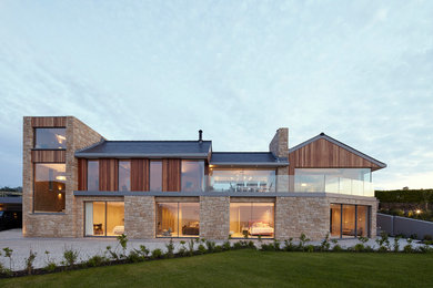 Aménagement d'une façade de maison beige contemporaine à un étage avec un revêtement mixte et un toit à deux pans.