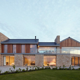 Inspiration for a beige contemporary two floor detached house in Channel Islands with mixed cladding and a pitched roof.
