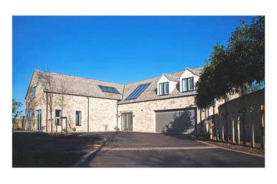 Imagen de fachada beige contemporánea de tamaño medio de dos plantas con revestimiento de piedra y tejado a dos aguas