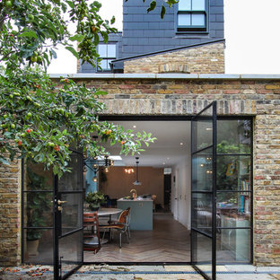 Idée de décoration pour une façade de maison design à un étage et de taille moyenne avec un toit plat.