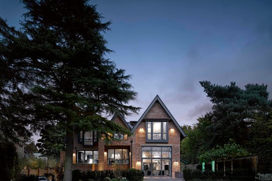 Imagen de fachada de casa beige moderna extra grande de dos plantas con revestimiento de ladrillo y tejado a dos aguas