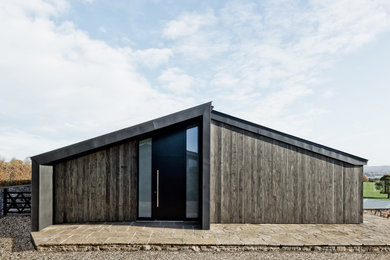 На фото: одноэтажный, серый частный загородный дом среднего размера в современном стиле с комбинированной облицовкой