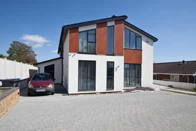 Photo of a medium sized and beige modern two floor house exterior in Sussex with wood cladding.