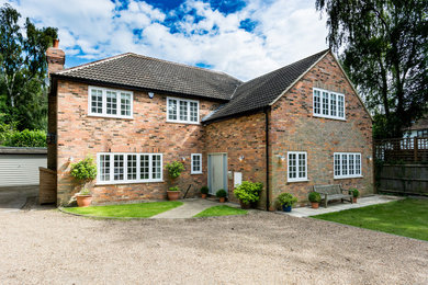 Medium sized classic two floor brick detached house in Hertfordshire with a hip roof and a tiled roof.