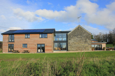 Inspiration for an expansive and multi-coloured farmhouse two floor detached house in Cornwall with wood cladding, a pitched roof and a tiled roof.