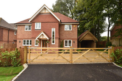 This is an example of a medium sized and brown classic two floor brick detached house in Surrey with a pitched roof and a tiled roof.