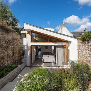 Ejemplo de fachada de casa blanca, contemporánea, pequeña, de una planta, con tejado plano y revestimiento de estuco