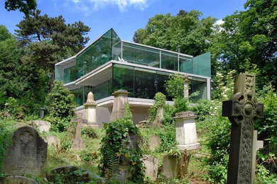 На фото: трехэтажный, стеклянный дом среднего размера в современном стиле с плоской крышей