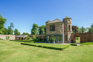 Photo of a traditional two floor house exterior in Other with stone cladding.