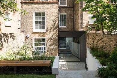 Brown modern brick house exterior in London with three floors.