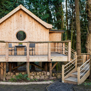 Esempio della facciata di una casa piccola marrone rustica a un piano con rivestimento in legno e tetto a capanna