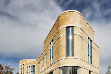 Imagen de fachada de casa contemporánea de dos plantas con revestimiento de piedra y tejado plano