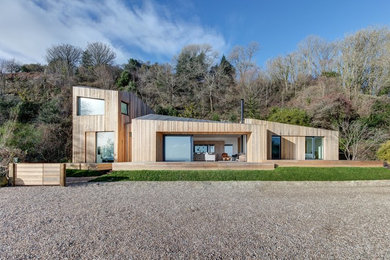 Zweistöckige Moderne Holzfassade Haus mit brauner Fassadenfarbe und Pultdach in Hampshire