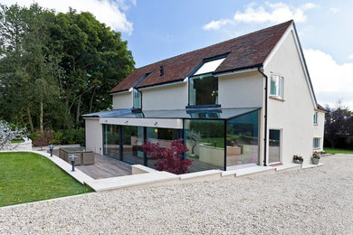 Ejemplo de fachada de casa blanca contemporánea de tres plantas con revestimiento de estuco, tejado a cuatro aguas y tejado de teja de barro
