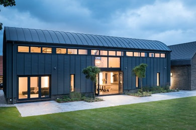 This is an example of a large and black contemporary two floor detached house in London with metal cladding.