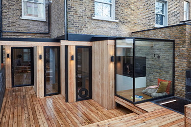 Inspiration for a medium sized and black contemporary bungalow terraced house in London with wood cladding.
