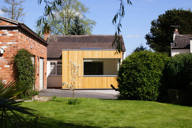 Inredning av ett modernt litet beige trähus, med allt i ett plan och platt tak