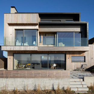 Design ideas for a beige modern detached house in Sussex with three floors, mixed cladding and a flat roof.