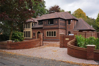 Cette photo montre une façade de maison rouge craftsman en brique de taille moyenne et à un étage avec un toit à quatre pans.