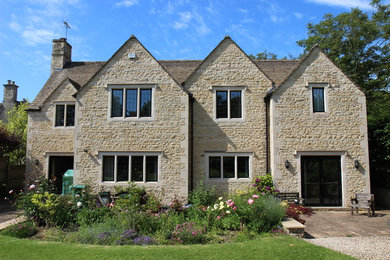 Photo of a large and multi-coloured rural two floor detached house in Gloucestershire with stone cladding, a pitched roof and a tiled roof.