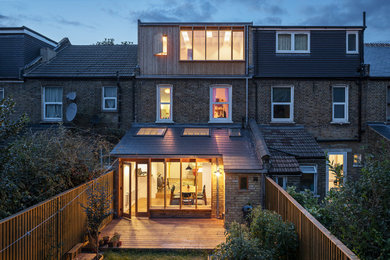 Design ideas for a contemporary house exterior in London with three floors and wood cladding.