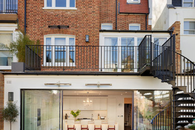 Large victorian brown three-story brick exterior home idea in London with a tile roof