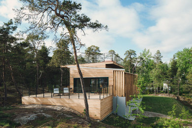 Diseño de fachada beige escandinava grande de tres plantas con revestimiento de madera y tejado plano