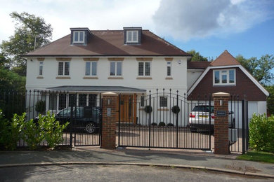 Large and beige contemporary render house exterior in Surrey with three floors and a hip roof.