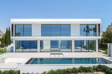 Inspiration for a white contemporary two floor detached house in Palma de Mallorca with mixed cladding and a flat roof.