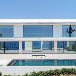 Ejemplo de fachada de casa blanca, contemporánea, de dos plantas, con revestimientos combinados y tejado plano