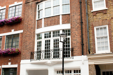 Design ideas for a red classic brick terraced house in London with three floors, a mansard roof and a tiled roof.
