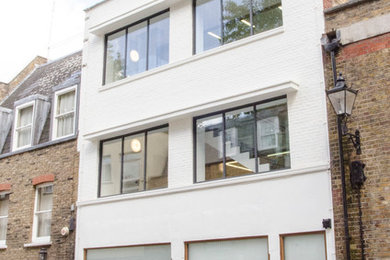 Design ideas for a medium sized and white contemporary brick house exterior in London with three floors.