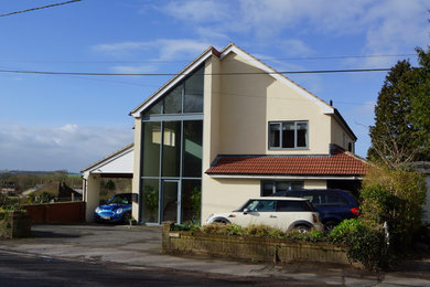 Mittelgroßes, Zweistöckiges Modernes Haus mit Putzfassade, beiger Fassadenfarbe und Satteldach in Wiltshire