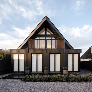 This is an example of a black contemporary two floor detached house in Sussex with a pitched roof.