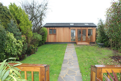 Photo of a medium sized rustic bungalow house exterior in Other with wood cladding.