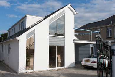 Photo of a small and yellow contemporary two floor render detached house in Devon with a pitched roof and a tiled roof.
