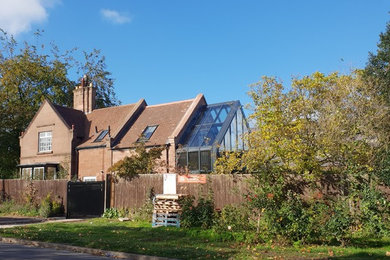 Modelo de fachada de casa actual de dos plantas con revestimiento de piedra, tejado a dos aguas y tejado de teja de barro