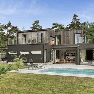 Inspiration för ett funkis grått hus, med två våningar, blandad fasad och platt tak
