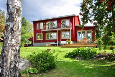 Foto de fachada de casa roja moderna de tres plantas con revestimiento de madera, tejado plano y tejado de metal