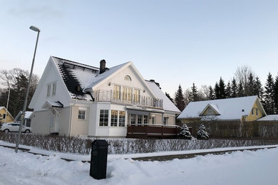 Imagen de fachada de casa blanca nórdica grande de dos plantas con revestimiento de madera, tejado a dos aguas y tejado de teja de barro