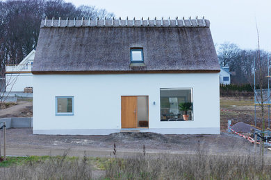 Imagen de fachada blanca escandinava de dos plantas con tejado a dos aguas