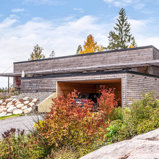 Foto på ett mellanstort skandinaviskt grått hus, med allt i ett plan och pulpettak