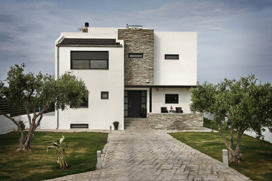 Imagen de fachada blanca minimalista grande de tres plantas con revestimiento de piedra y tejado de un solo tendido