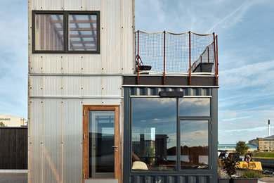 Diseño de fachada industrial de dos plantas con revestimiento de metal y tejado plano