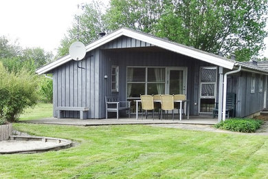 Modelo de fachada de casa gris escandinava de tamaño medio de una planta con revestimiento de madera, tejado a dos aguas y tejado de metal