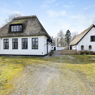Inredning av ett lantligt vitt hus, med två våningar, sadeltak och levande tak