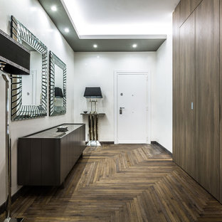 Idee per un corridoio design con pareti bianche, parquet scuro, una porta bianca, una porta singola e pavimento marrone