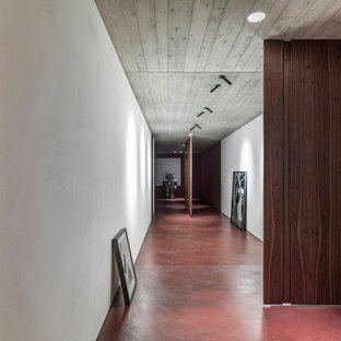 Modern inredning av en stor hall, med betonggolv och rött golv