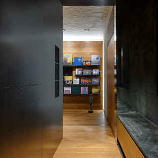 Foto di un ingresso o corridoio minimal con pareti nere, pavimento in legno massello medio e pavimento marrone