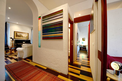 Immagine di un ingresso o corridoio minimalista di medie dimensioni con pareti bianche e pavimento in legno verniciato